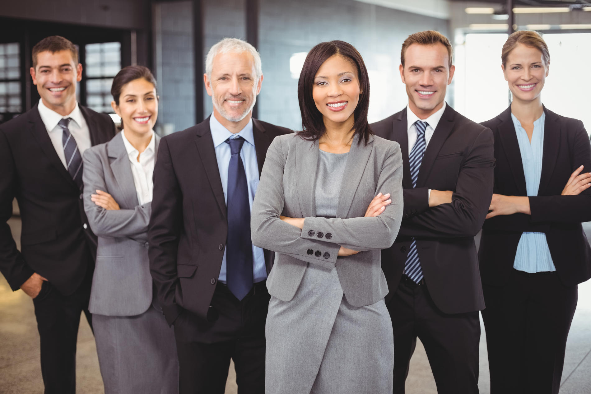 Portrait of businesspeople standing with arms crossed in office